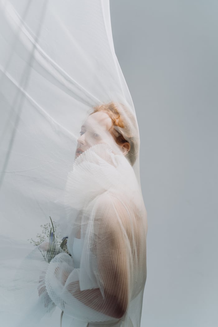 Woman in White Long Sleeve Top Holding a Bouquet of Flowers